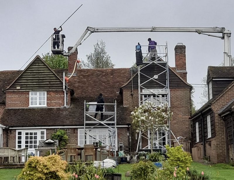 The Moss Cleaners using cherry picker and scaffolding to clean roof safely and professionally in Redhill, Surrey